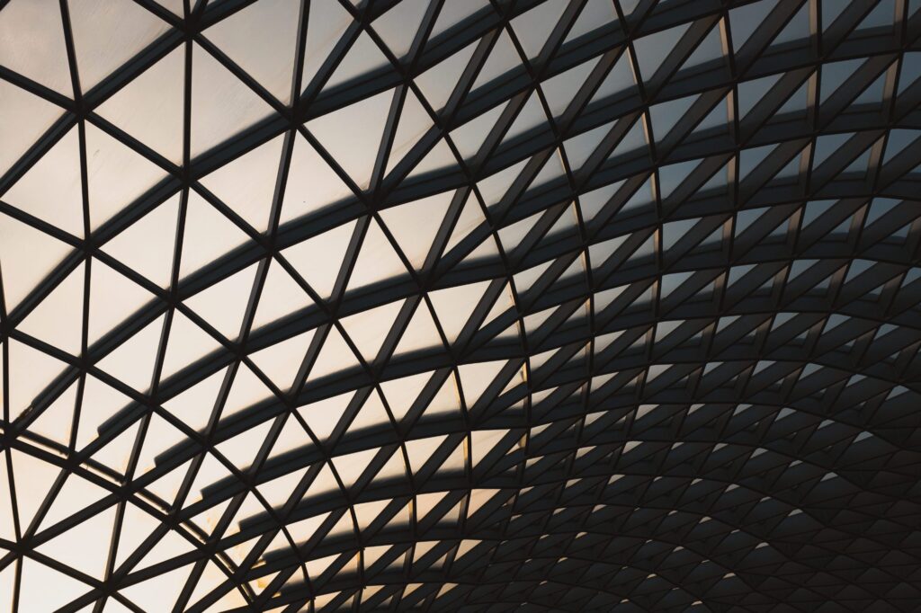 A gridded glass and steel roof canopy curving overhead.